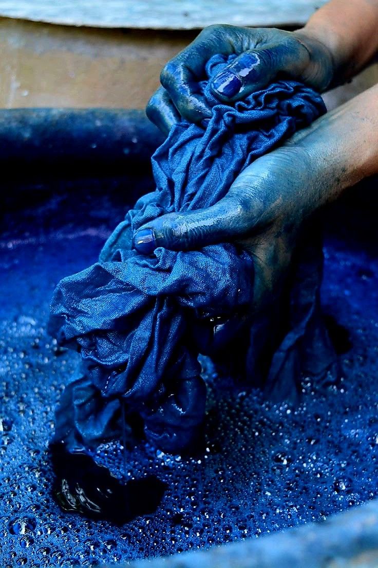 Hands, working freshly dyed indigo cloth